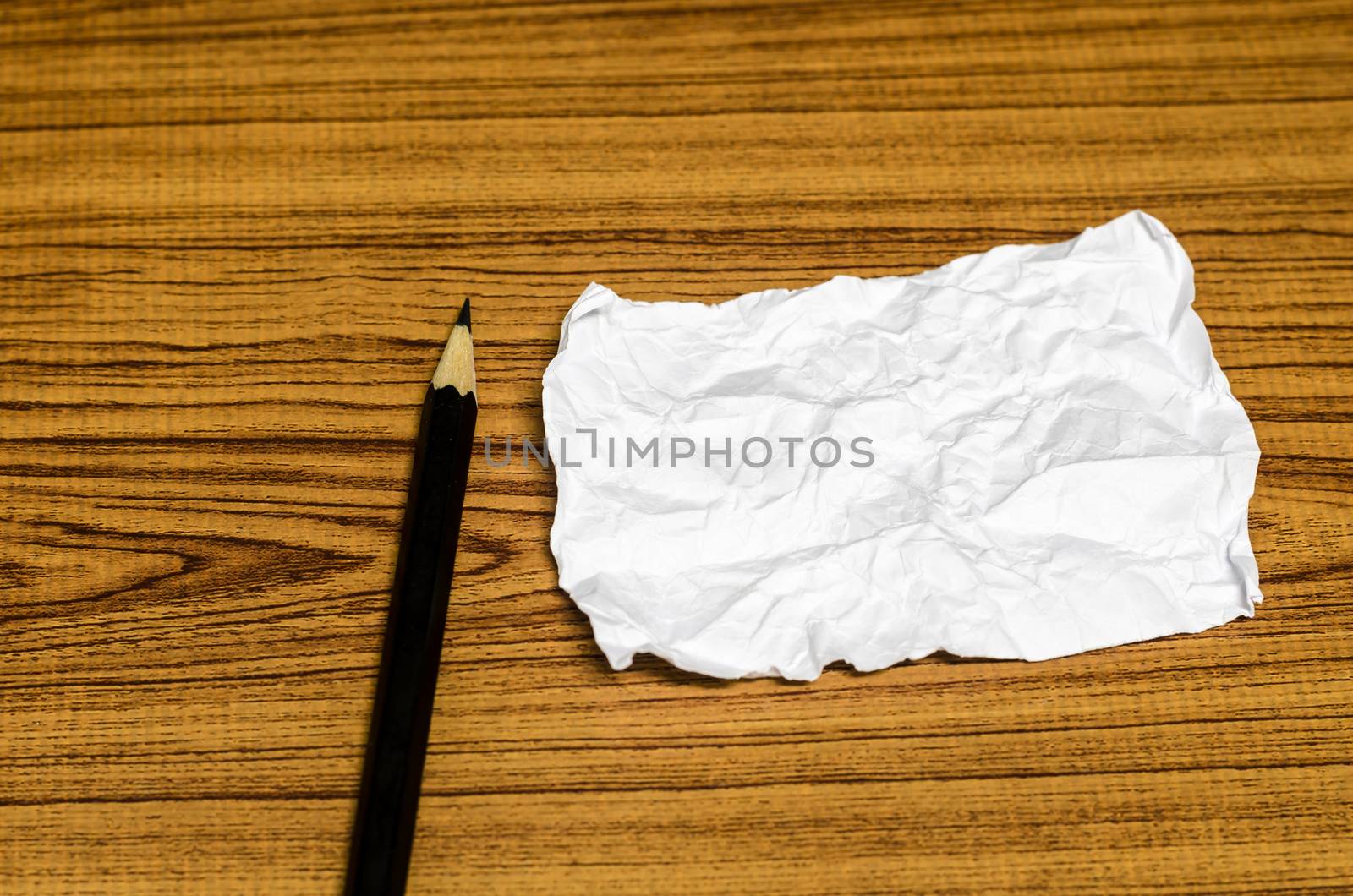 paper scrap with pencil on wood background