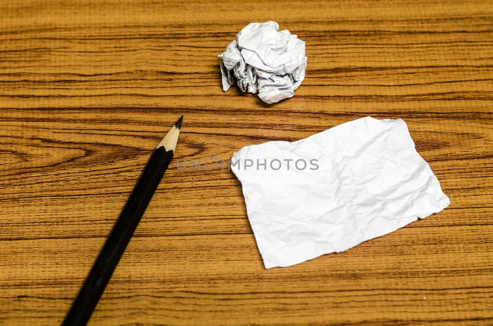 paper scrap and crumpled with pencil on wood background
