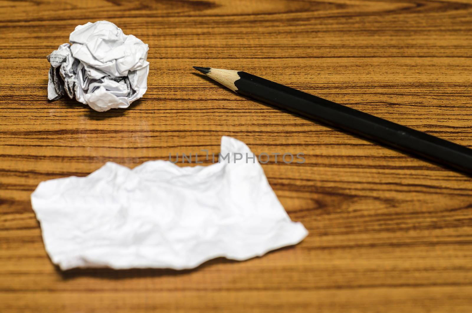 paper scrap and crumpled with pencil on wood background