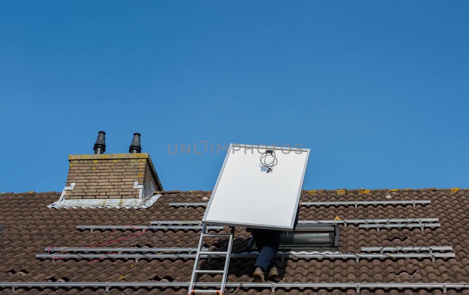 man climbing the ladder with solar panel by compuinfoto