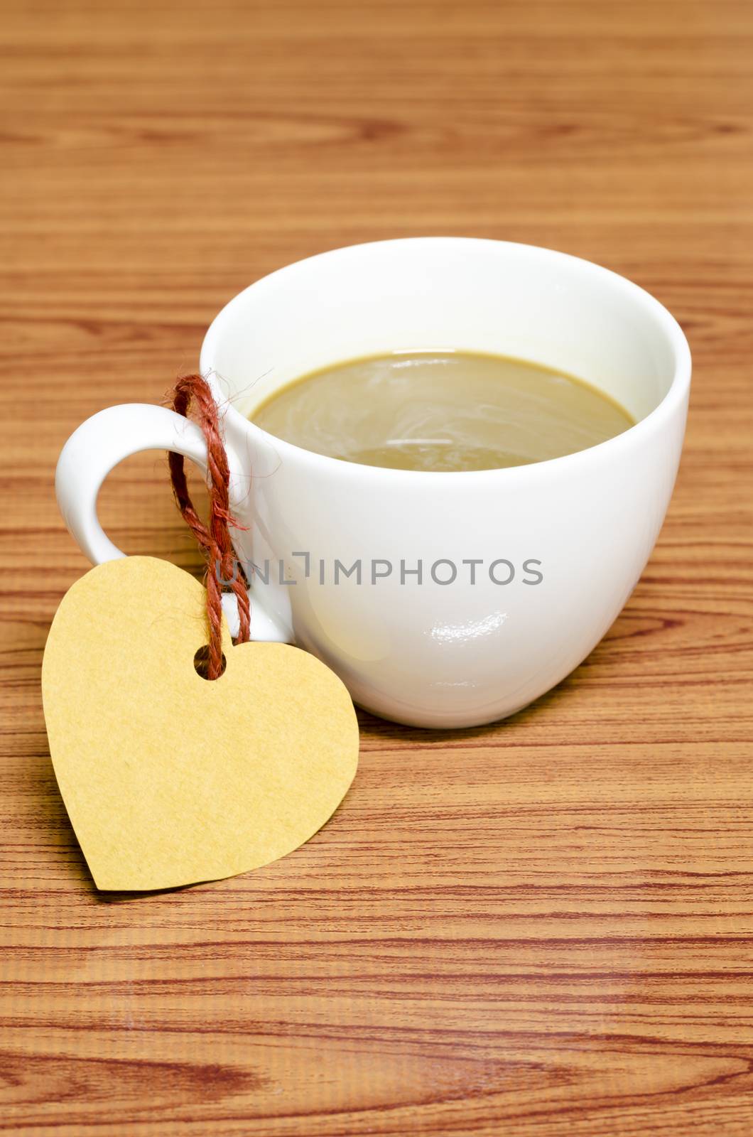 coffee cup with heart tag on wood background