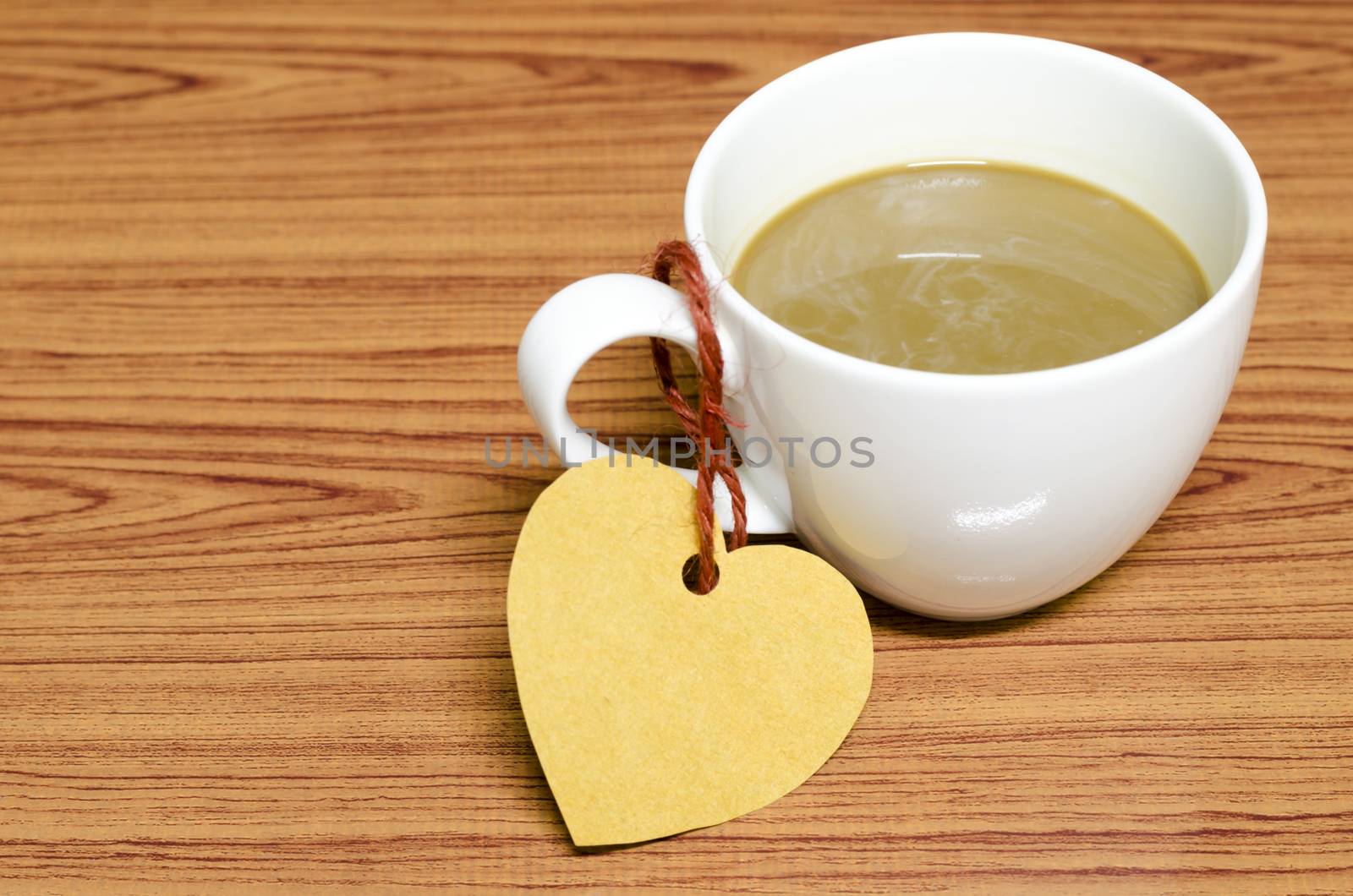 coffee cup with heart tag on wood background