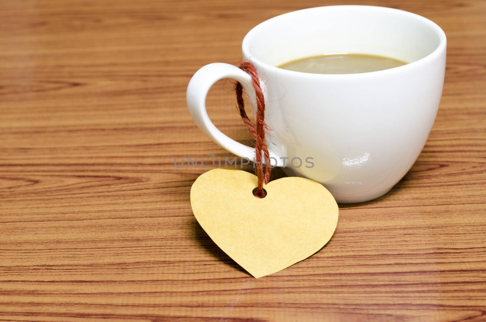 coffee cup with heart tag on wood background
