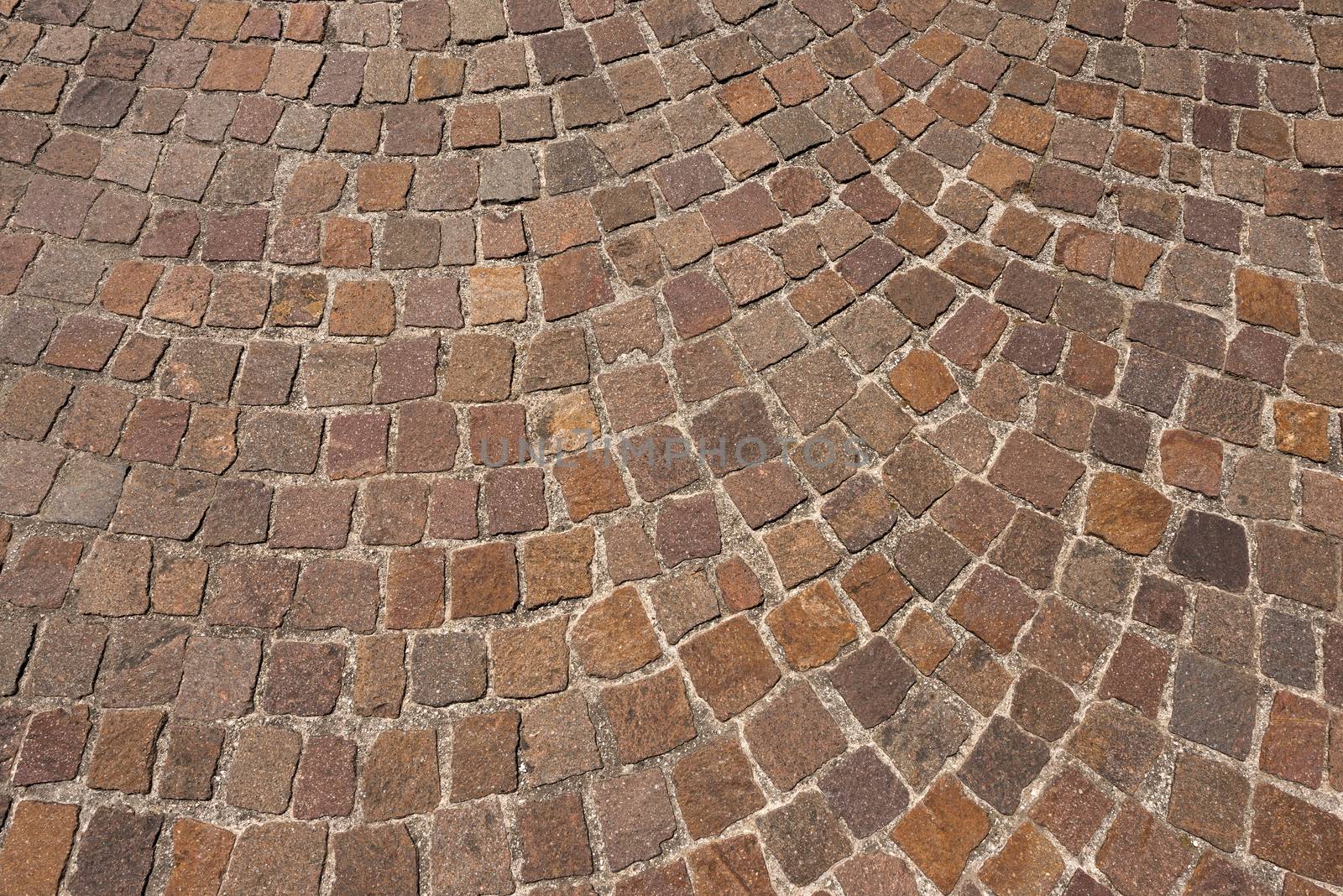 Geometric floor with multi colored blocks of porphyry (sanpietrini), typical urban paving in Italy