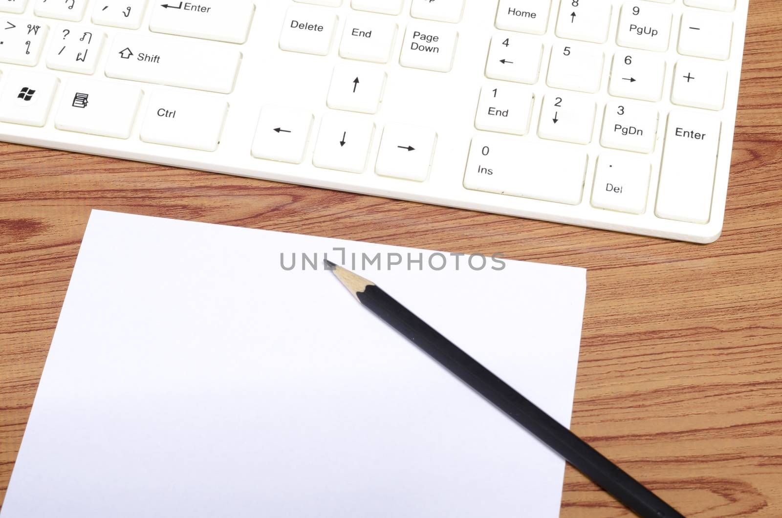 keyboard computee white paper and black pencil on wood background