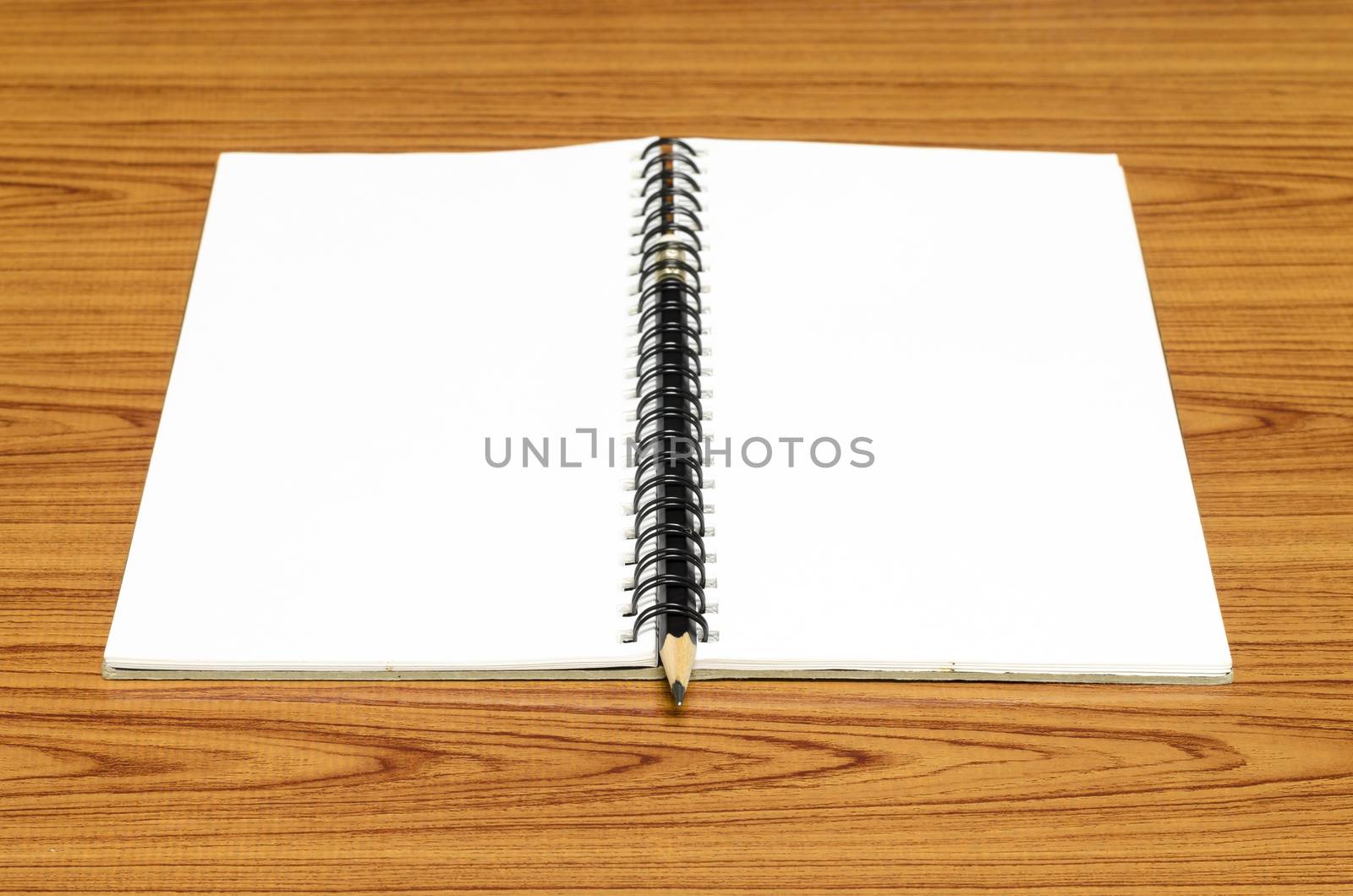 notebook and pencil on wood background