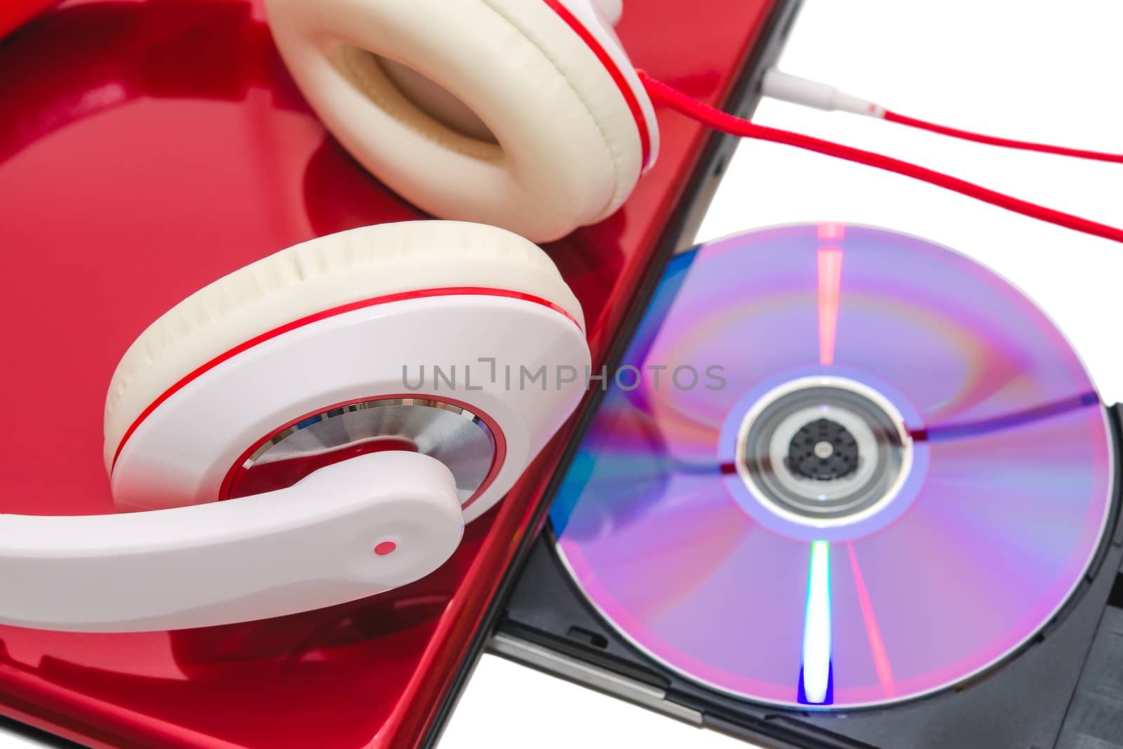 Portable computer with DVD compact disc and red white headphones isolated