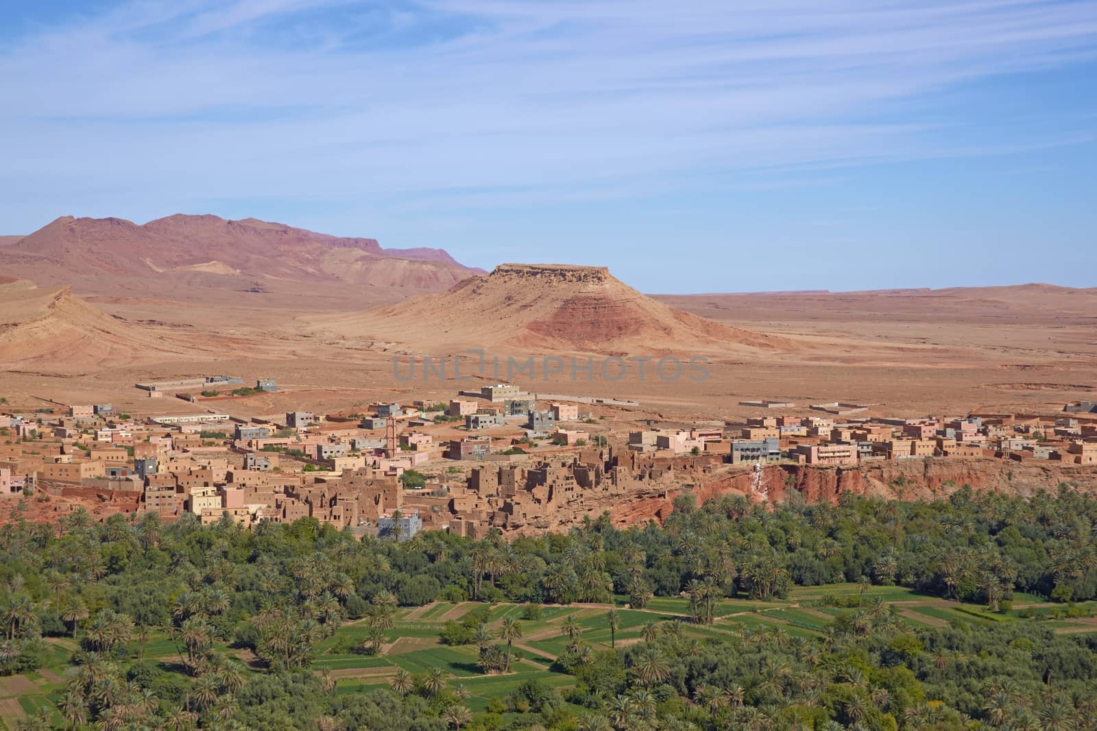 Traditional Berber village and cultivated fields along a river valley in the foothills of the Atlas Mountains in Morocco