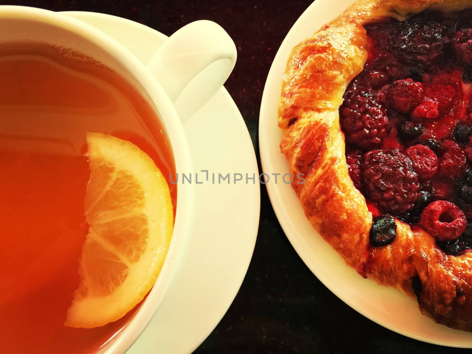 Raspberry pastry and a cup of tea with lemon.