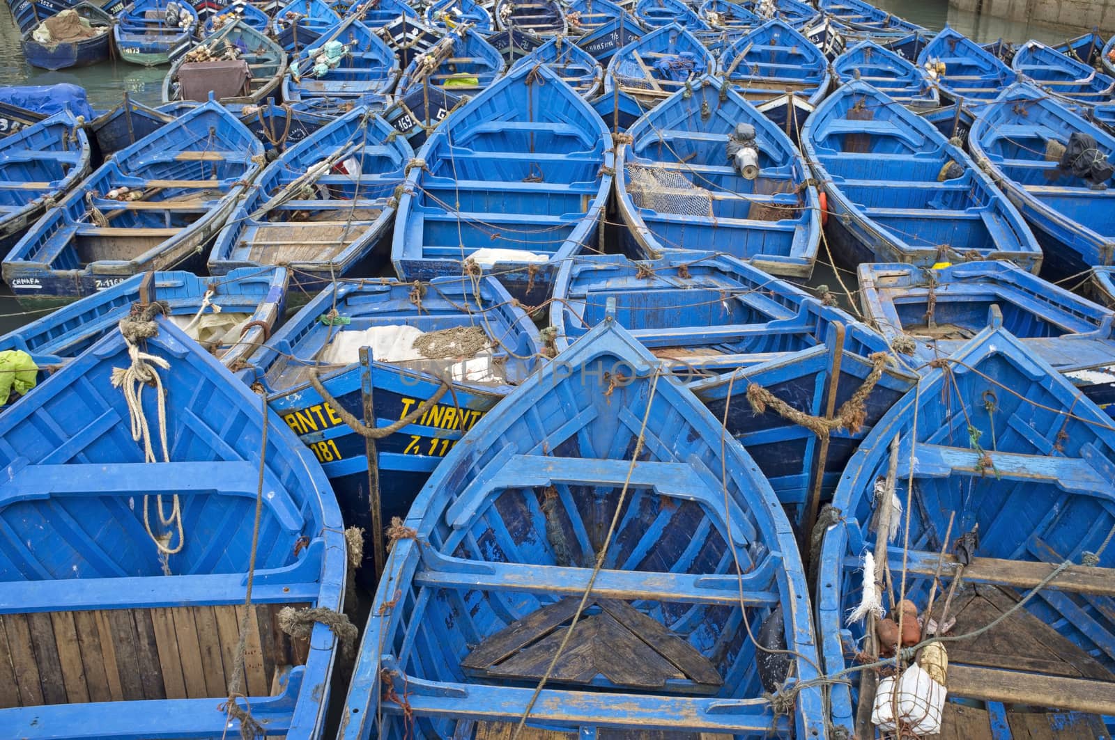 Small wooden fishing boats inside the historic harbour of Essaouira in Morocco.