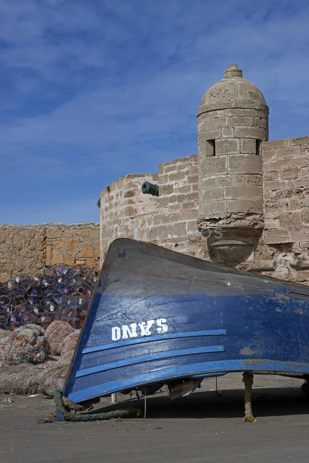 Small wooden fishing boat on the dockside inside the historic harbour of Essaouira in Morocco.
