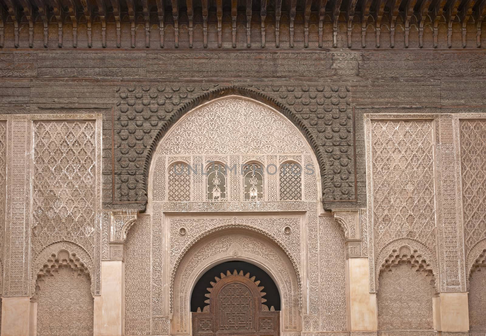 Ornate carving on the plastered walls and on the woodwork in the courtyard of the historic Ben Youssef Madrasa in the ancient heart of Marrakech in Morocco