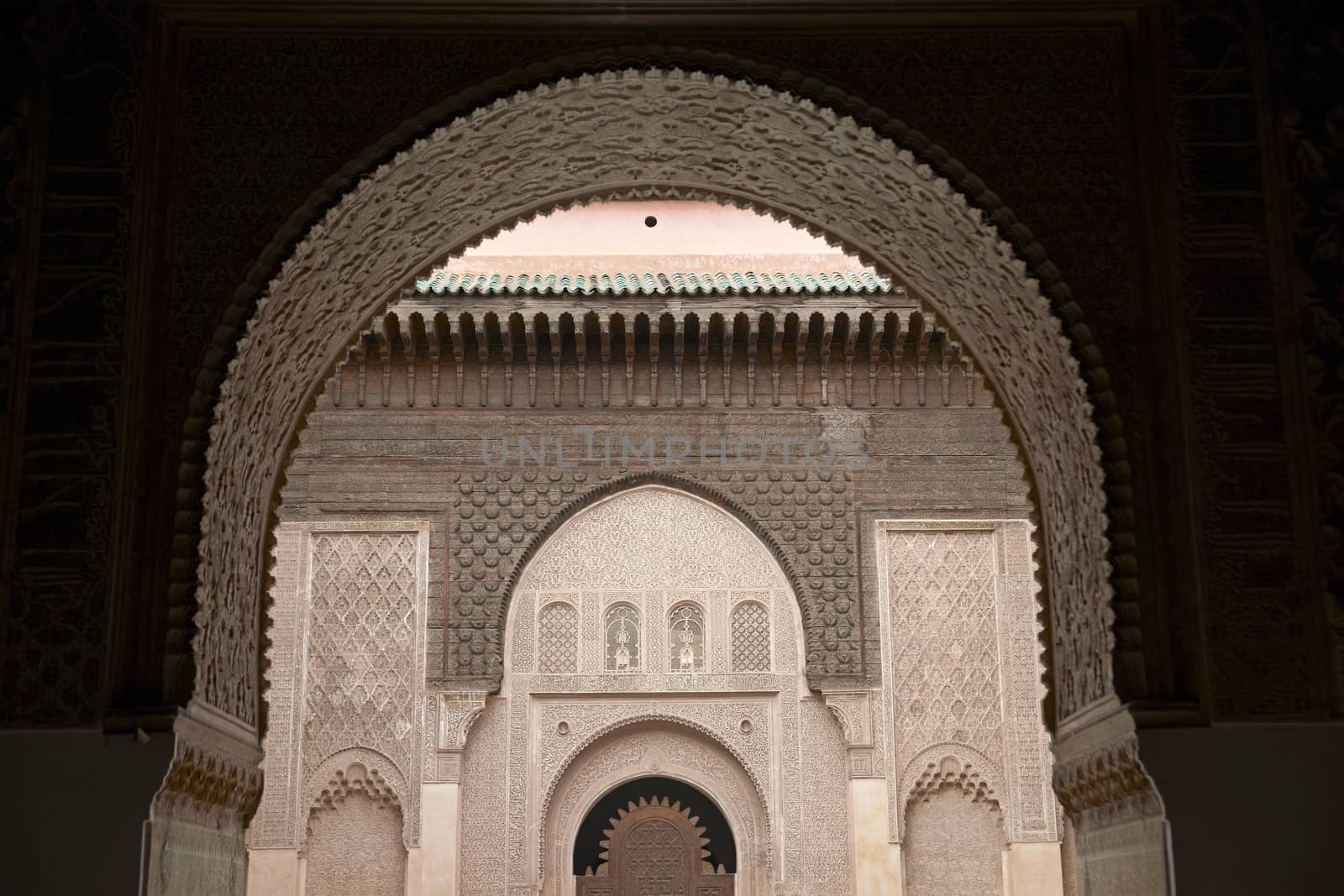 Ornate carving on the plastered walls and on the woodwork in the courtyard of the historic Ben Youssef Madrasa in the ancient heart of Marrakech in Morocco