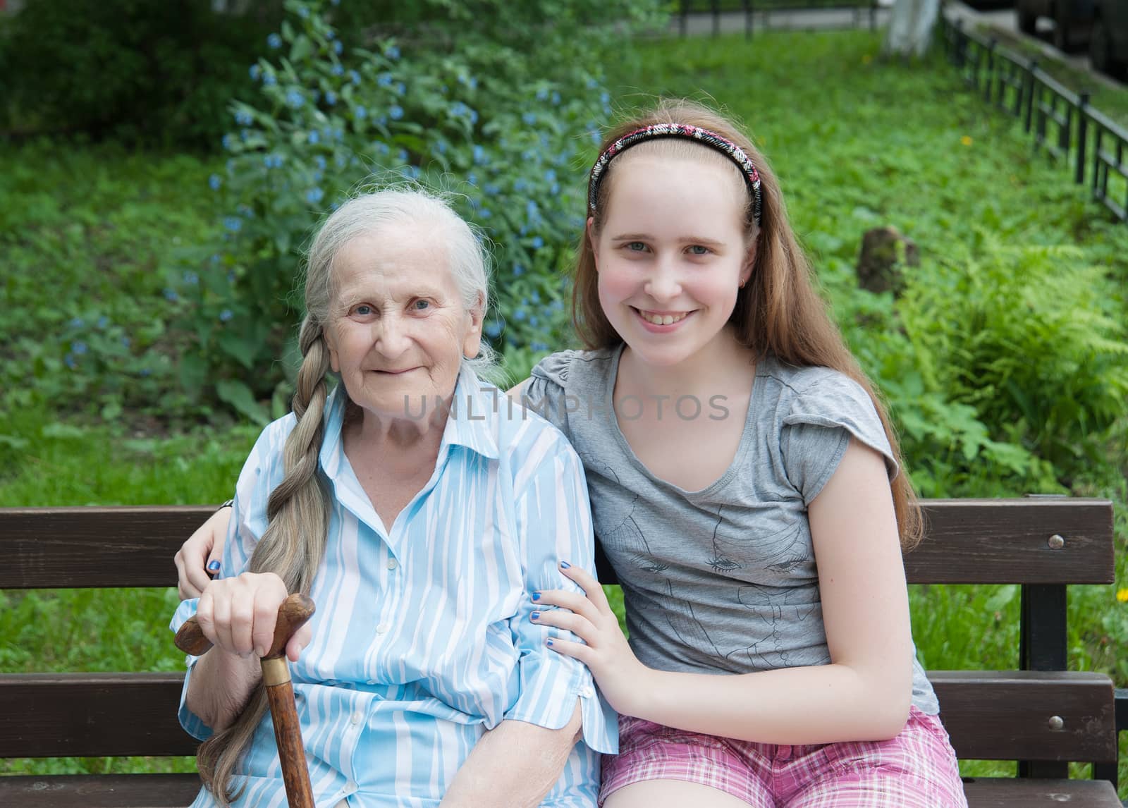 granddaughter tenderly embraces jet grandmother with a stick