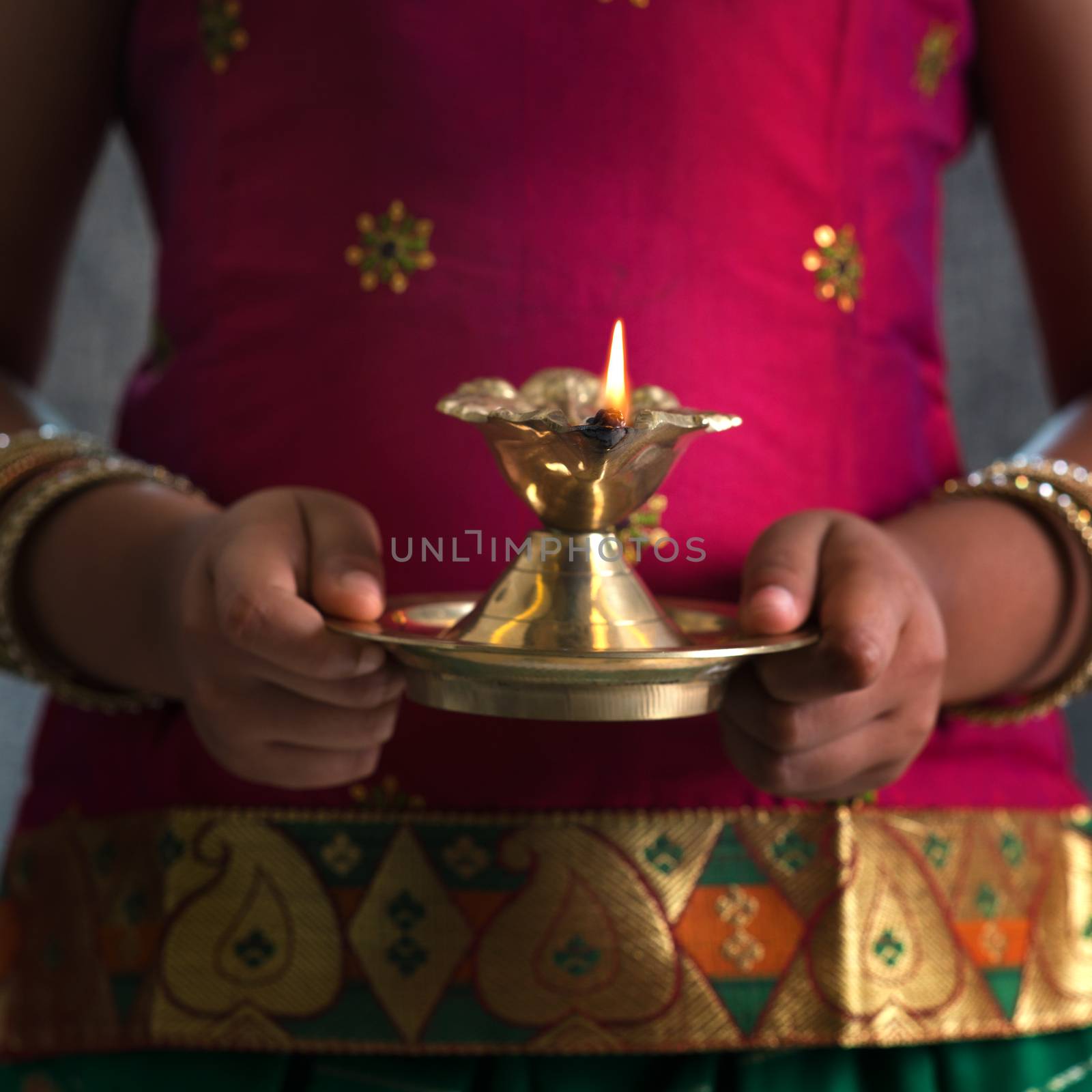 Diwali or deepavali photo with female hands holding oil lamp during festival of light.
