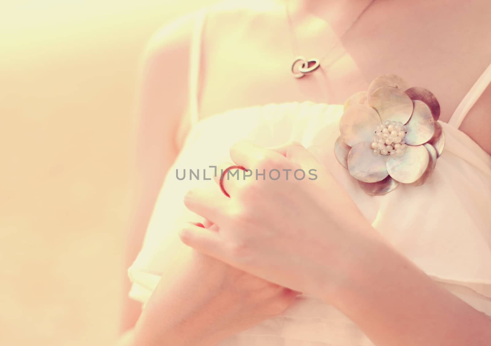 Close up of bride's hands with accessory for dress, retro filter by nuchylee