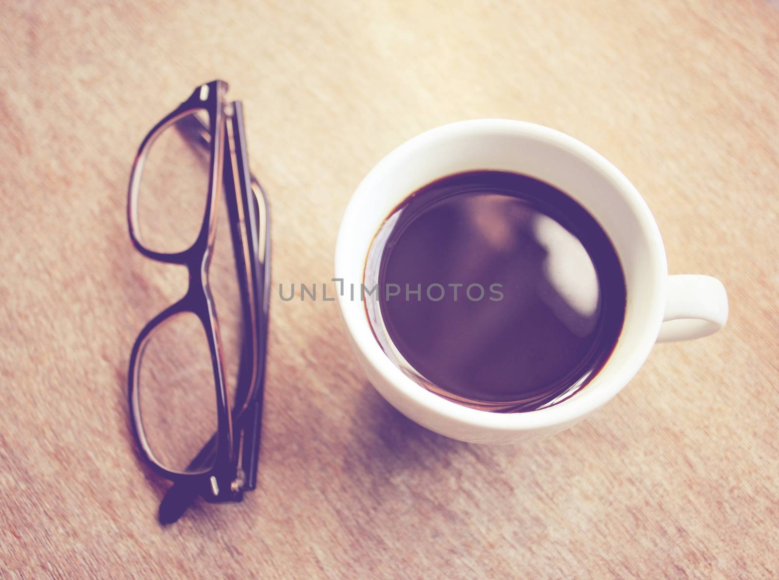 Hot coffee and eyeglasses with retro filter effect