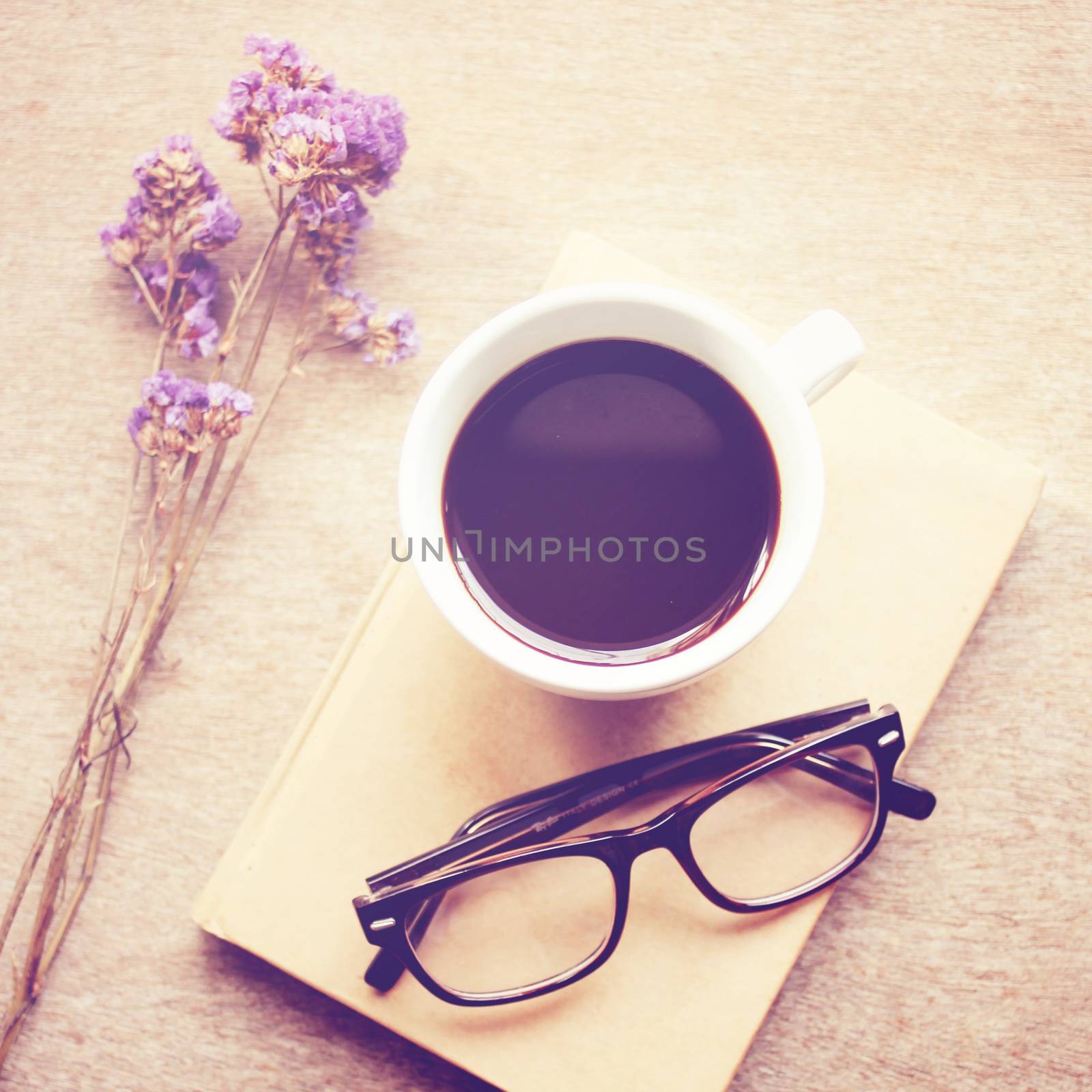 Black coffee on notebook with eyeglasses, retro filter effect