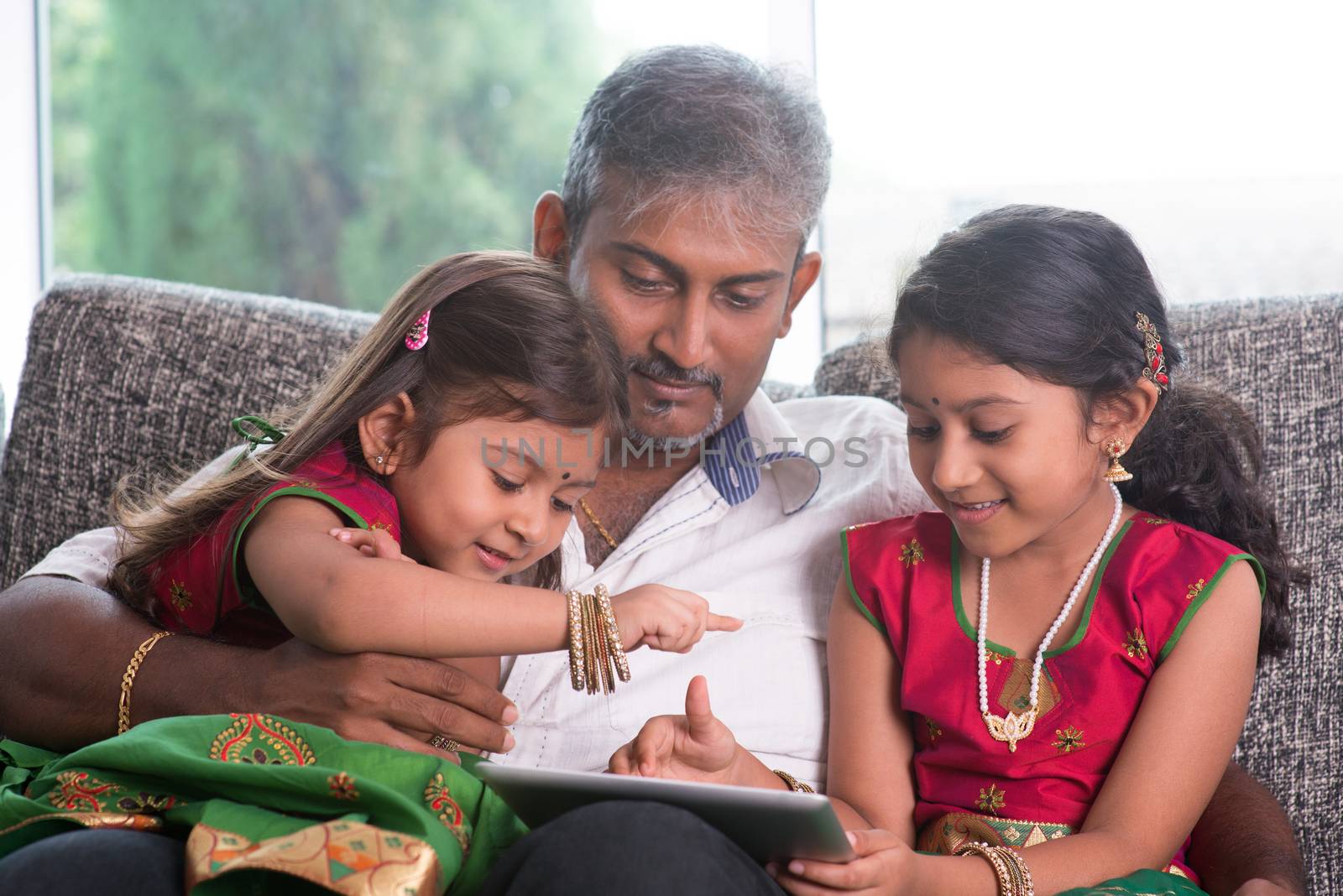 Indian family using tablet computer. by szefei
