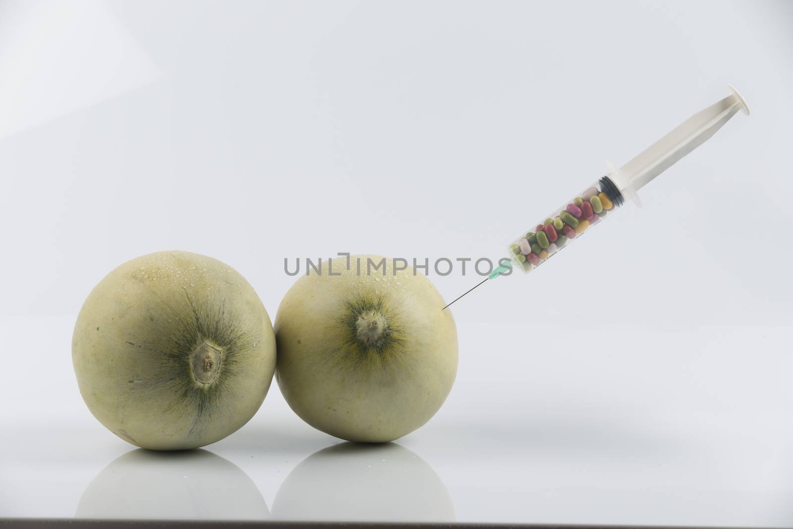 Cosmetic treatment  for Female breasts metaphor: melons and syringe with pills meaning cosmetic and health treatment