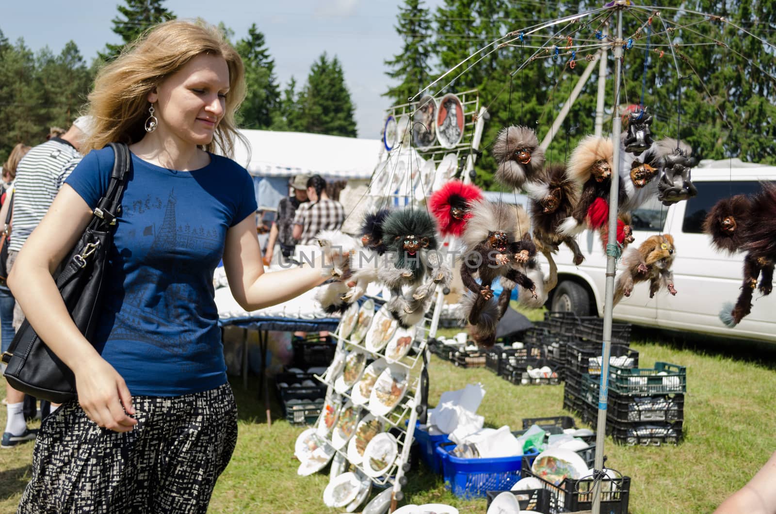 ANYKSCIAI, LITHUANIA - JUNE 01 : young blonde woman browse fair handmade wares on June 01, 2013 in Anyksciai.
