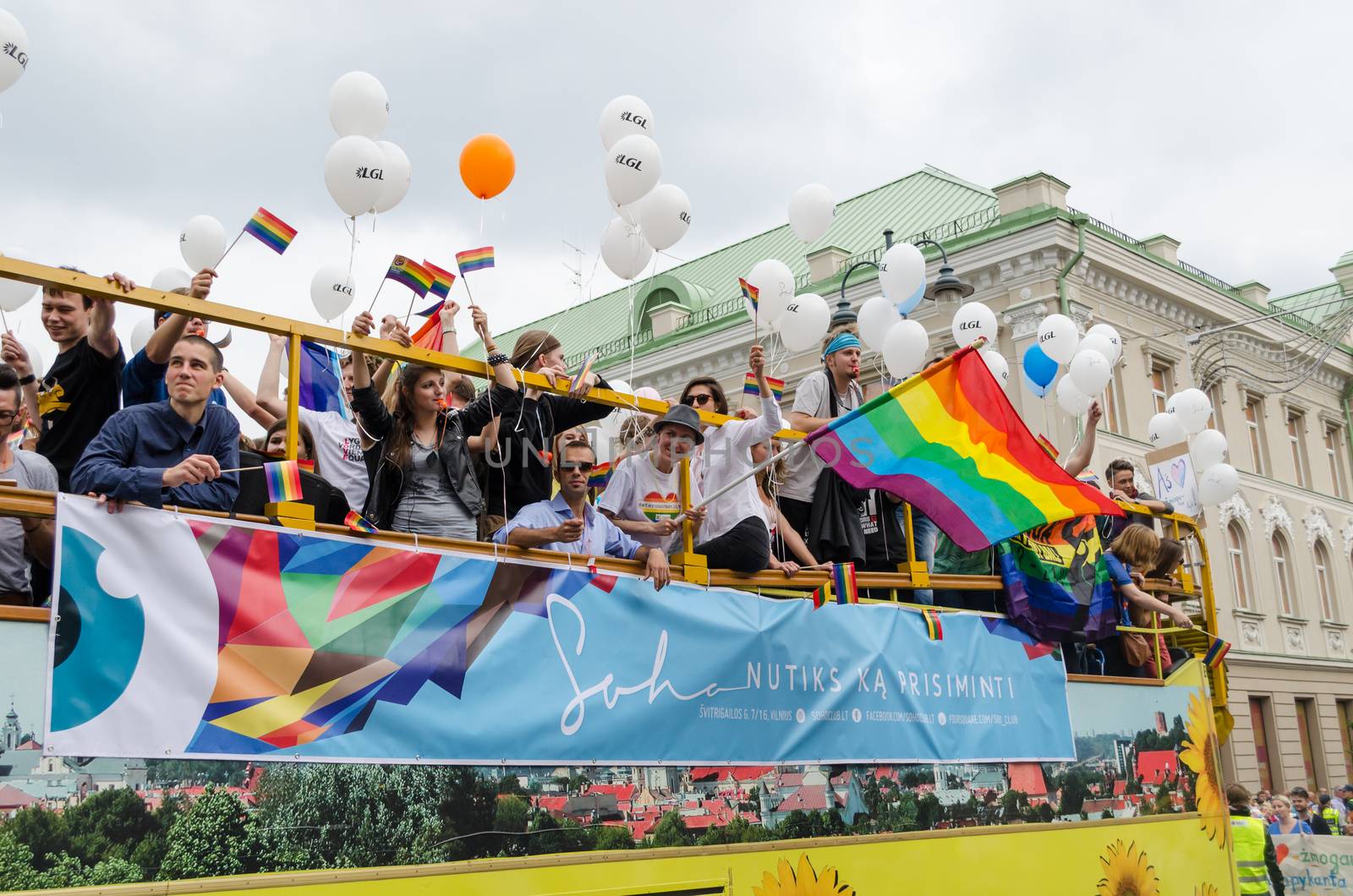 VILNIUS, LITHUANIA - JULY 27: open bus rides large group of participants in the Baltic pride gay parade with banners balloons flags on July 27, 2013 in Vilnius.