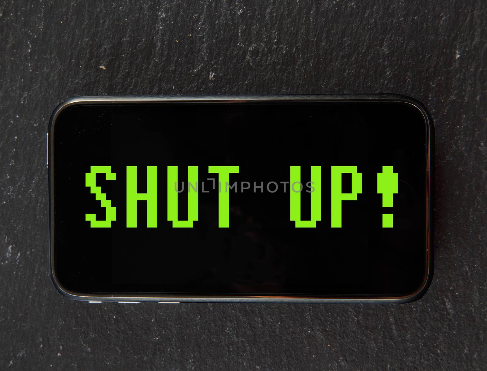 Smartphone with text "Shut up" in vintage computer font