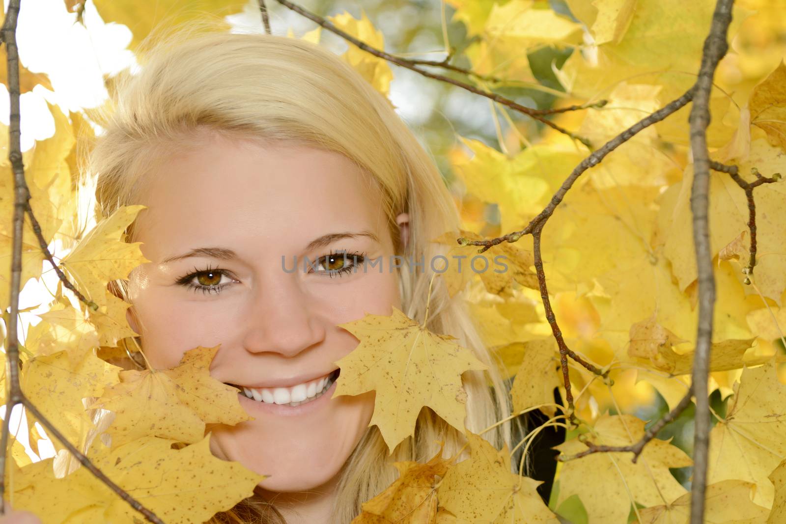cheerful young blond woman  in autumn park
