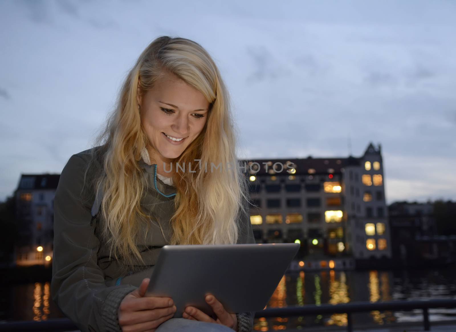 pretty young blond woman with tablet computer in the city