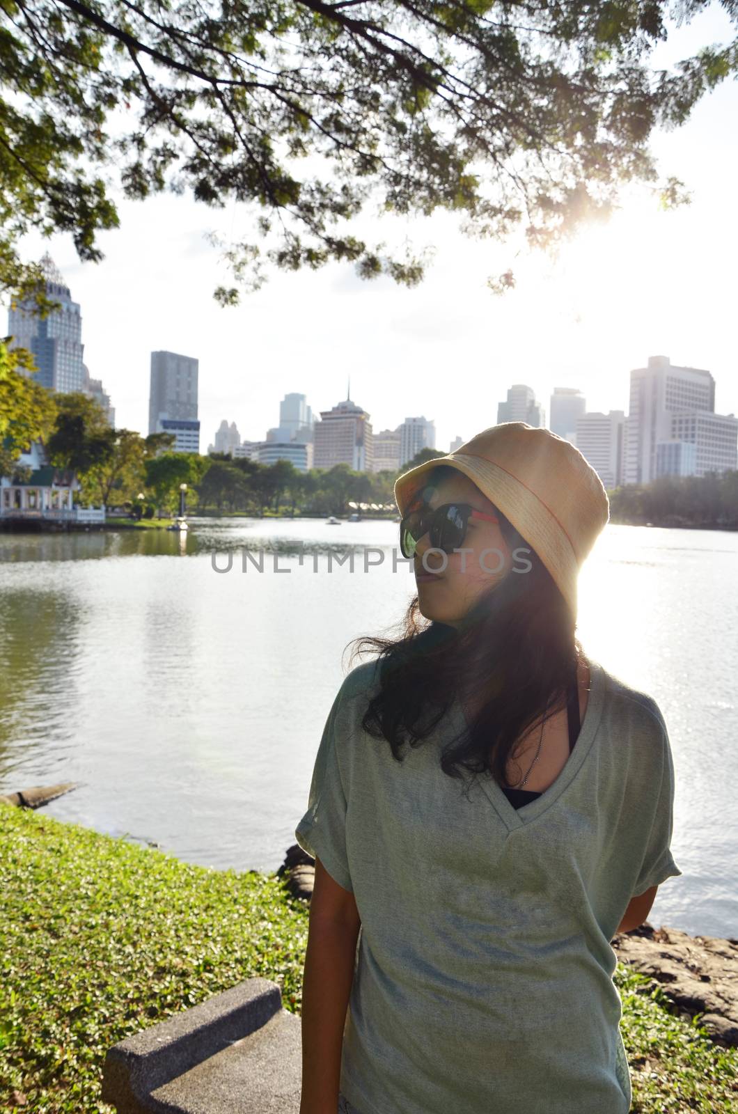 Fashion girl at public park, sunset time by siraanamwong