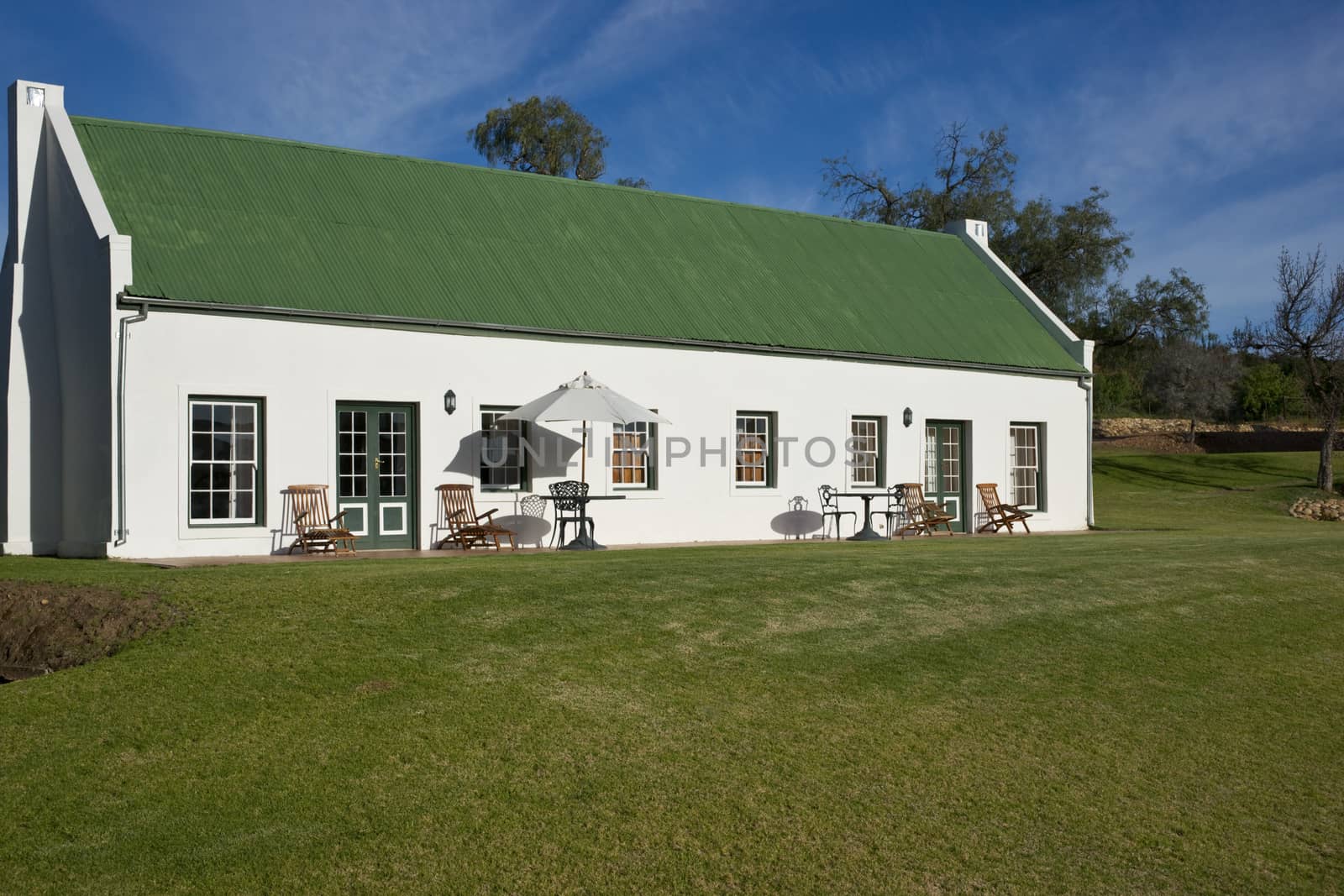 Farm cottage built in traditional Cape architectural style set in landscaped grounds in the Oudtshoorn region of the Western Cape in South Africa