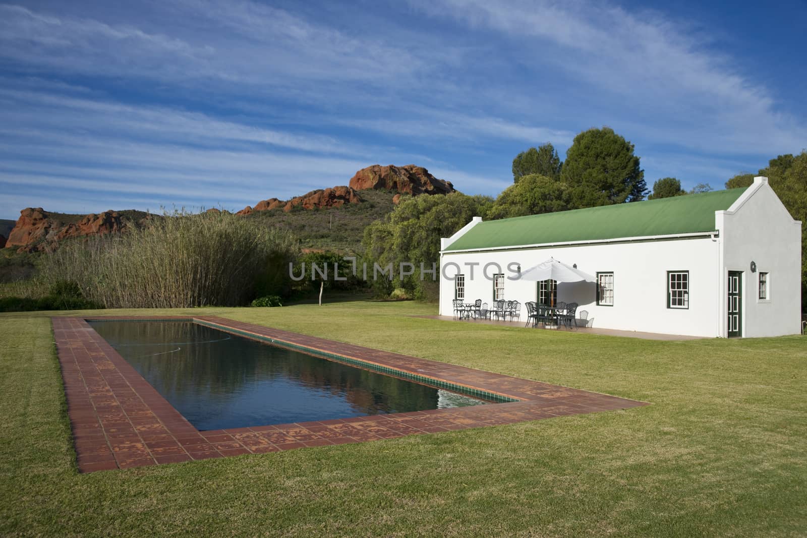 Farm cottage built in traditional Cape architectural style set in landscaped grounds in the Oudtshoorn region of the Western Cape in South Africa