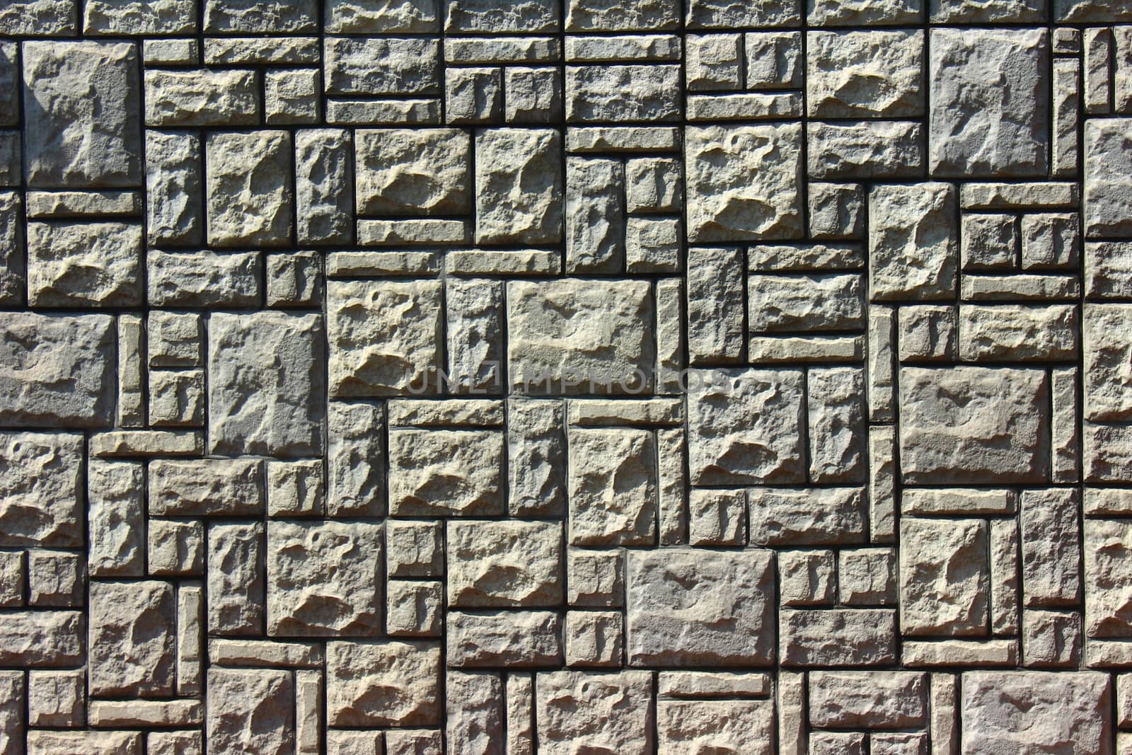wall of gray bricks of different shapes