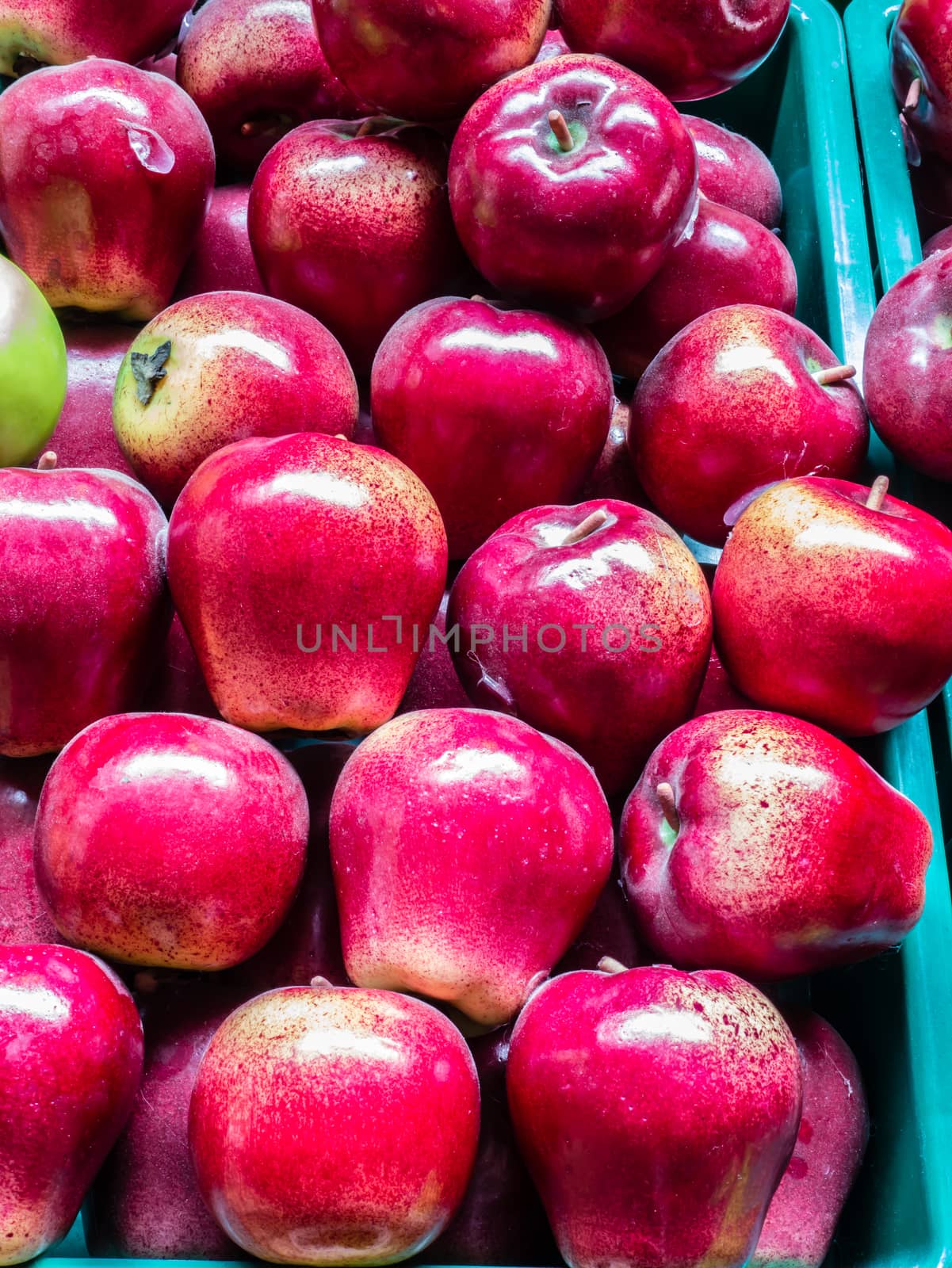 the red apples in green plastic crates