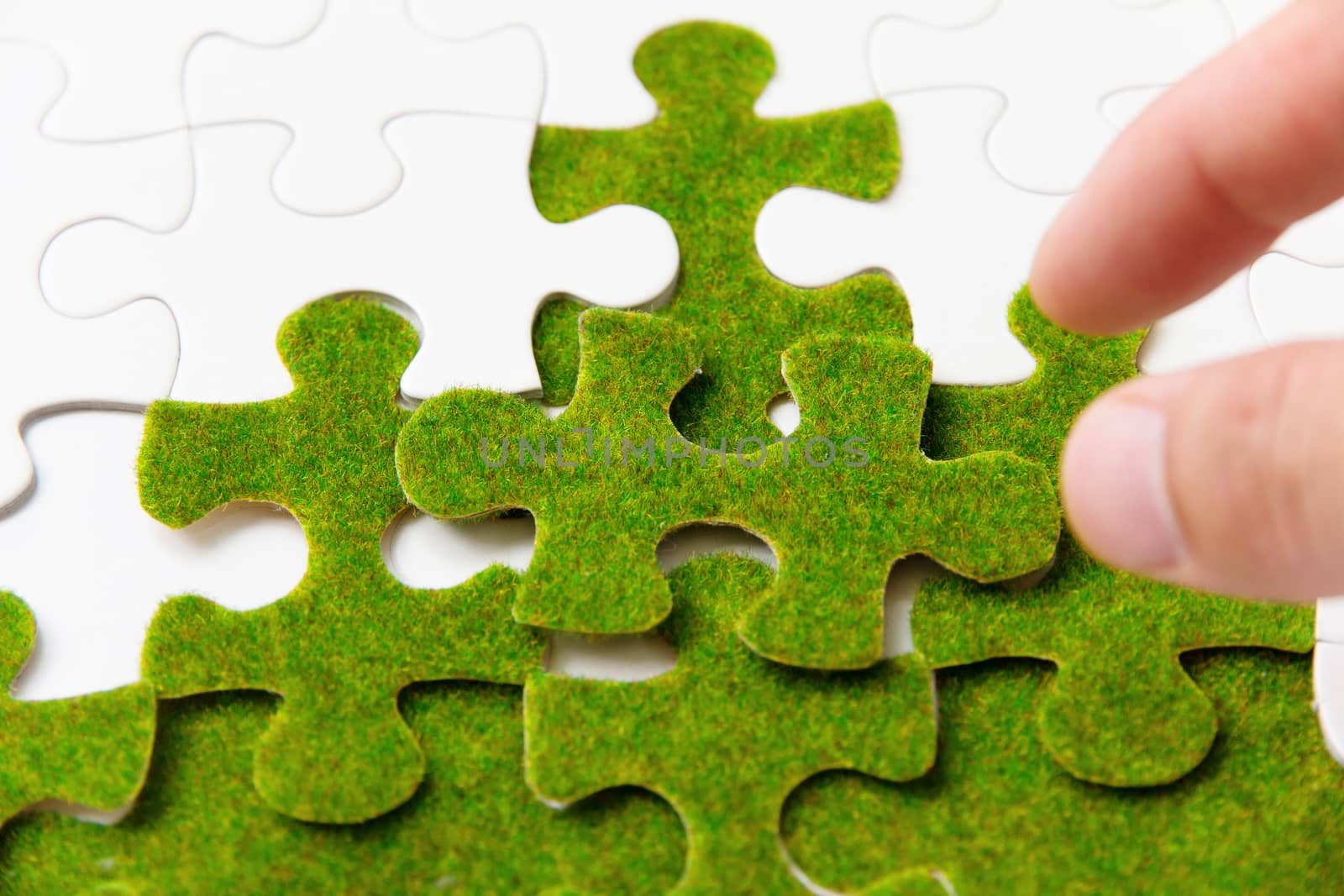 hand holding a green puzzle piece, green space concept