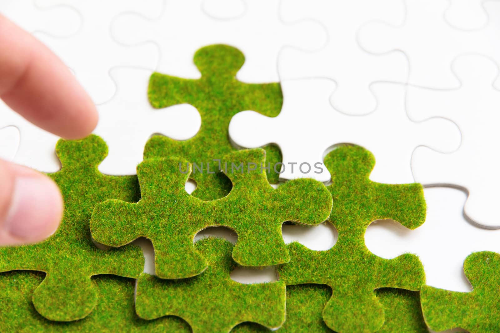 hand holding a green puzzle piece, green space concept
