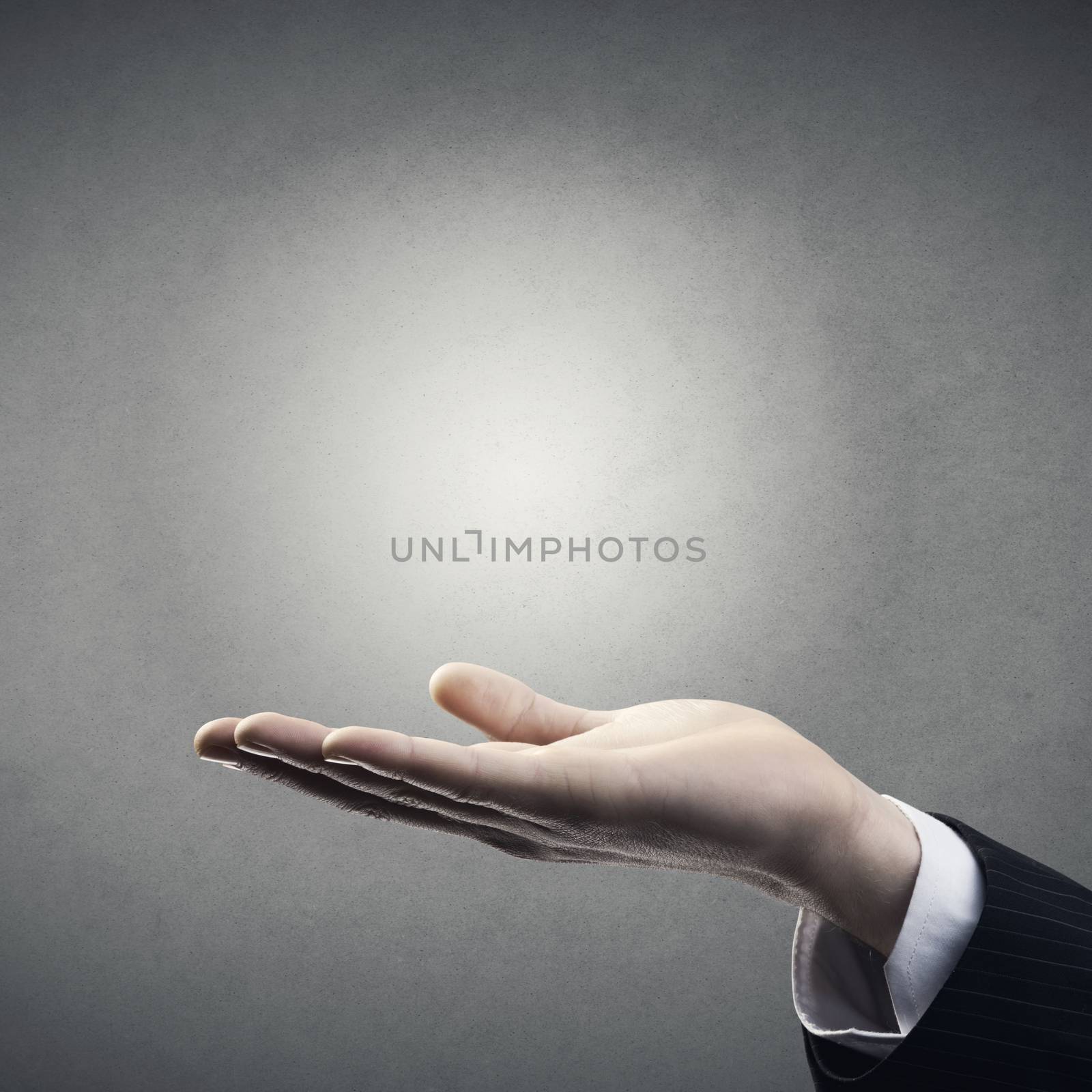 Elegant open businessman hand with copyspace on gray background.