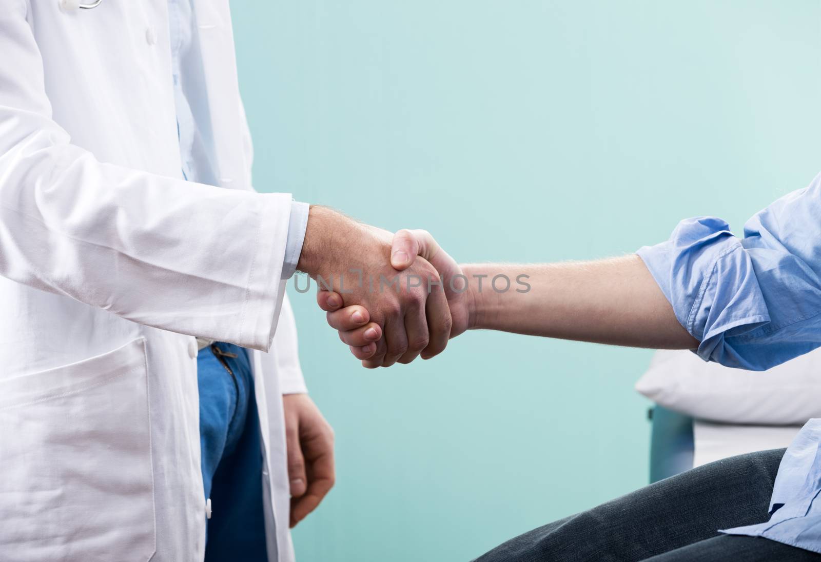 Doctor and patient handshake close-up at the clinic.