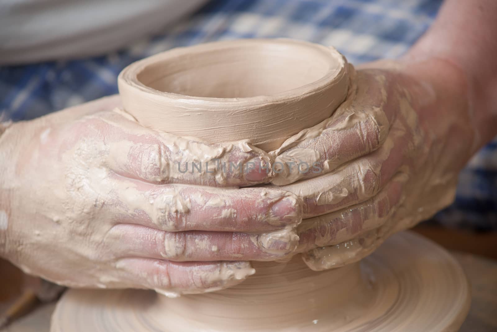 Hands of a potter, creating an earthen jar on the circle