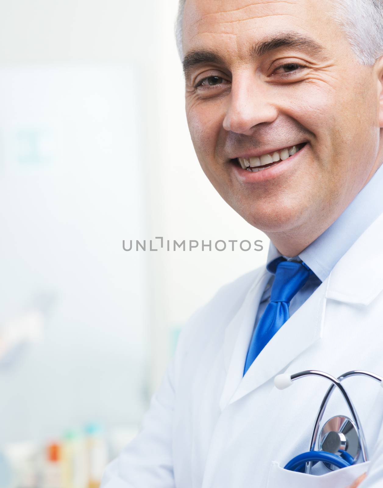 Handsome friendly doctor smiling and looking at camera.