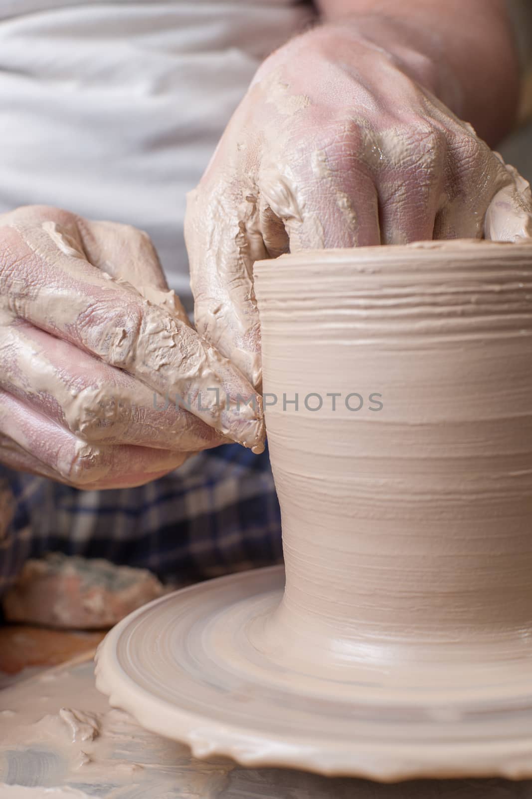 Hands of a potter, creating an earthen jar on the circle