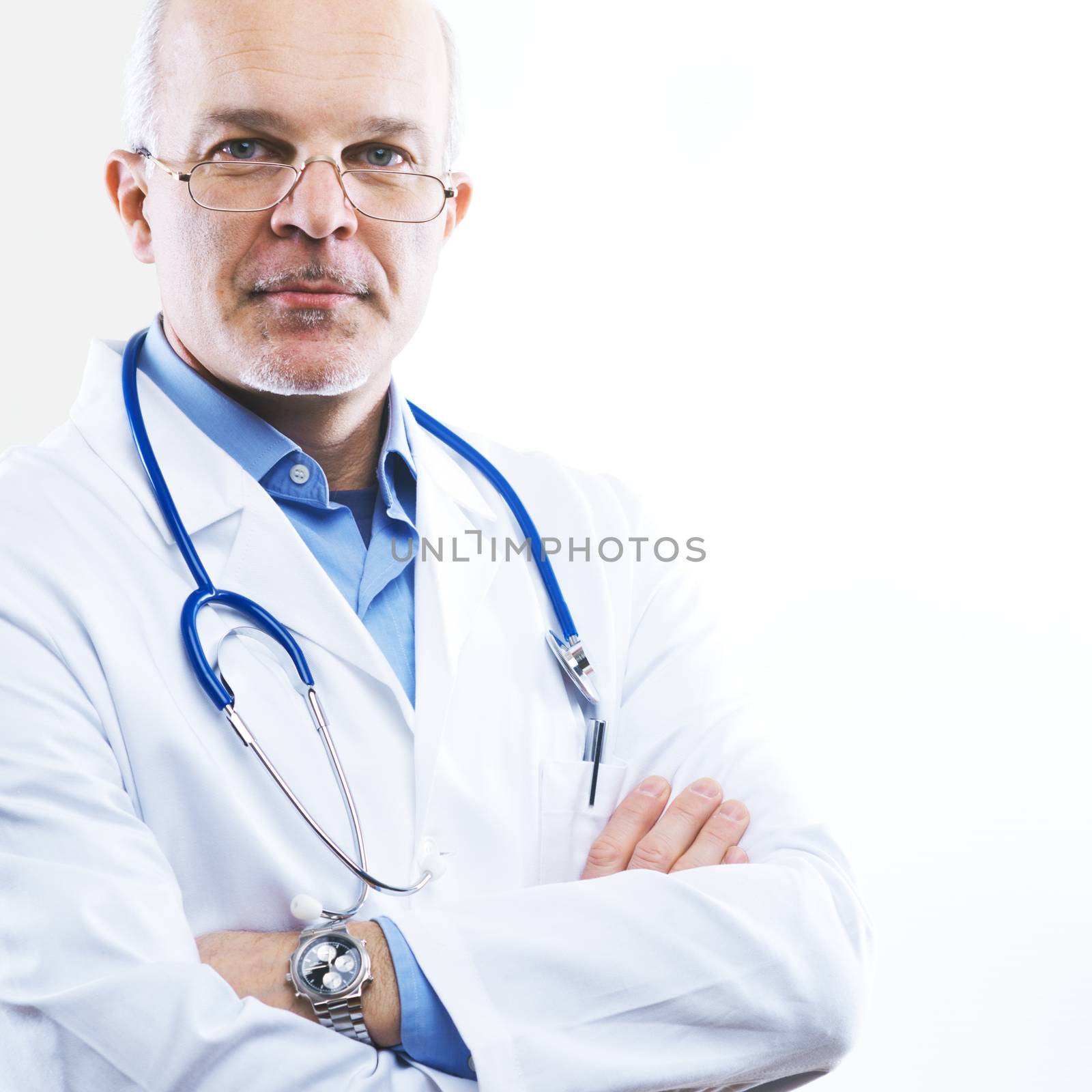 Senior confident doctor in a clinic with arms crossed.