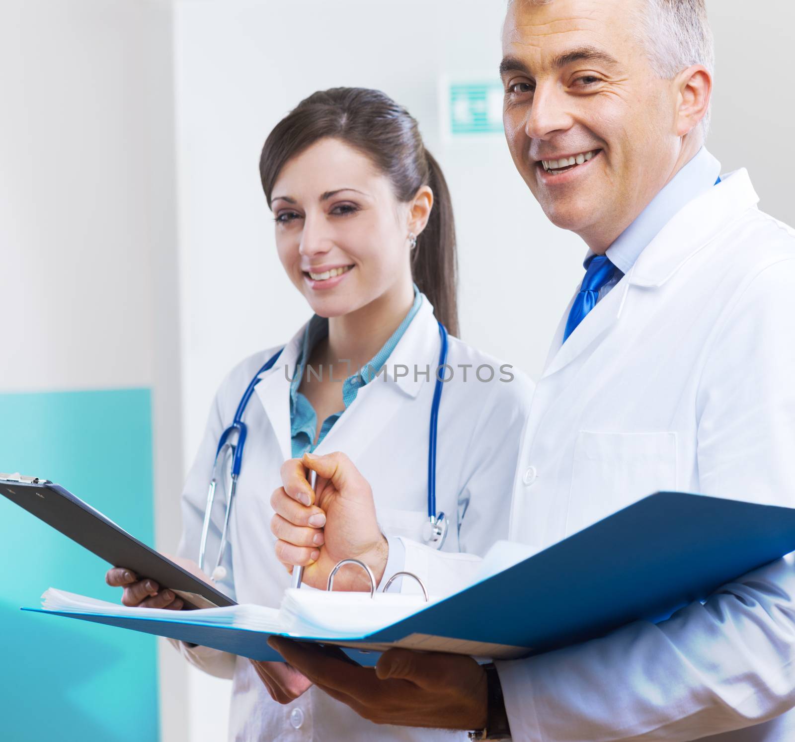 Young assistant and doctor checking medical records and documents.