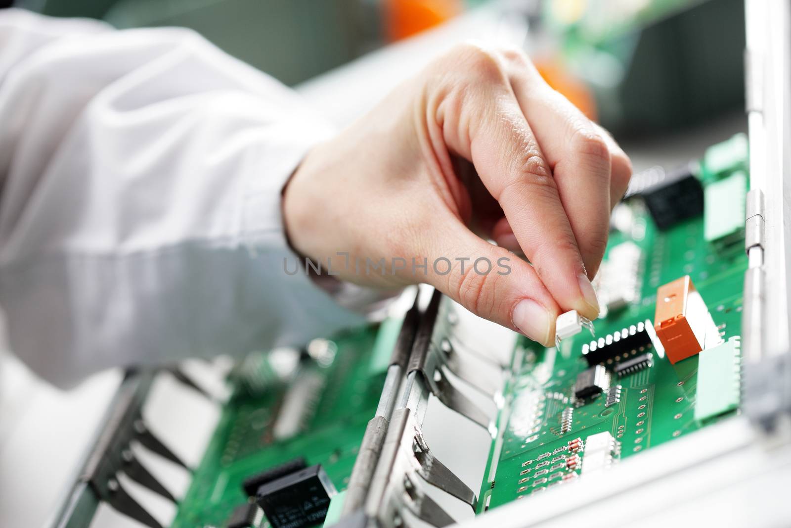 Technician assembling electonic components at his worktable.