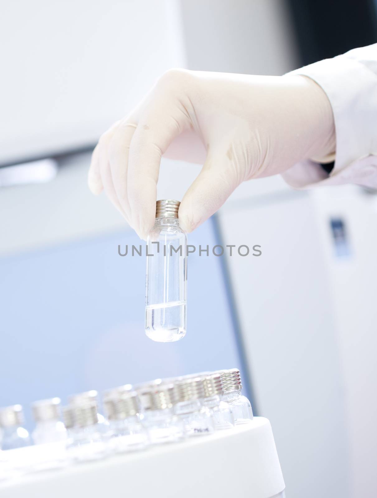 Technician loading sample vials in autosampler rack.