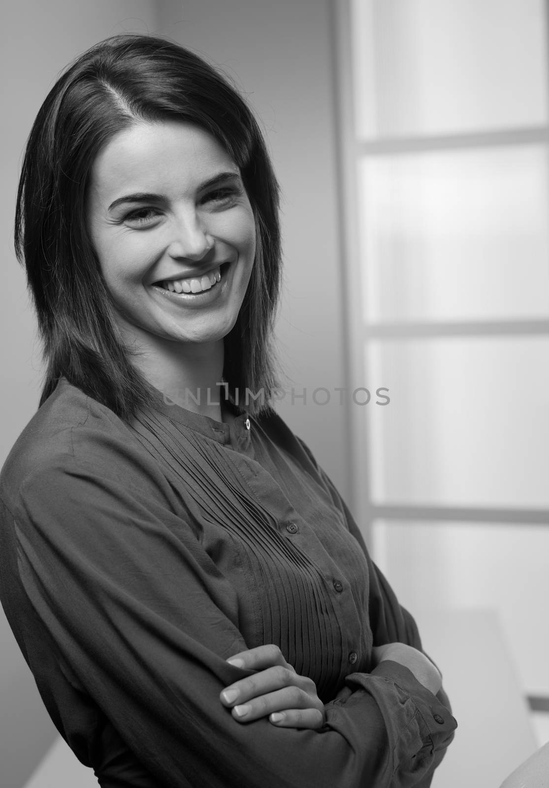 Attractive young woman smiling with arms crossed.