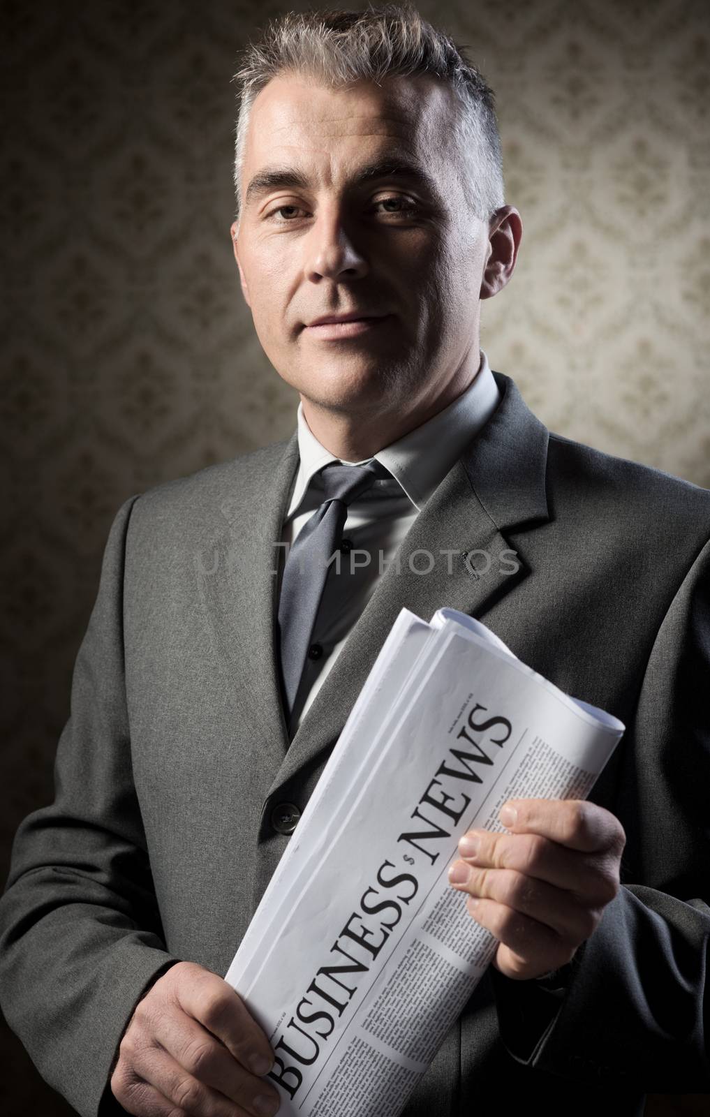 Businessman holding newspaper by stokkete