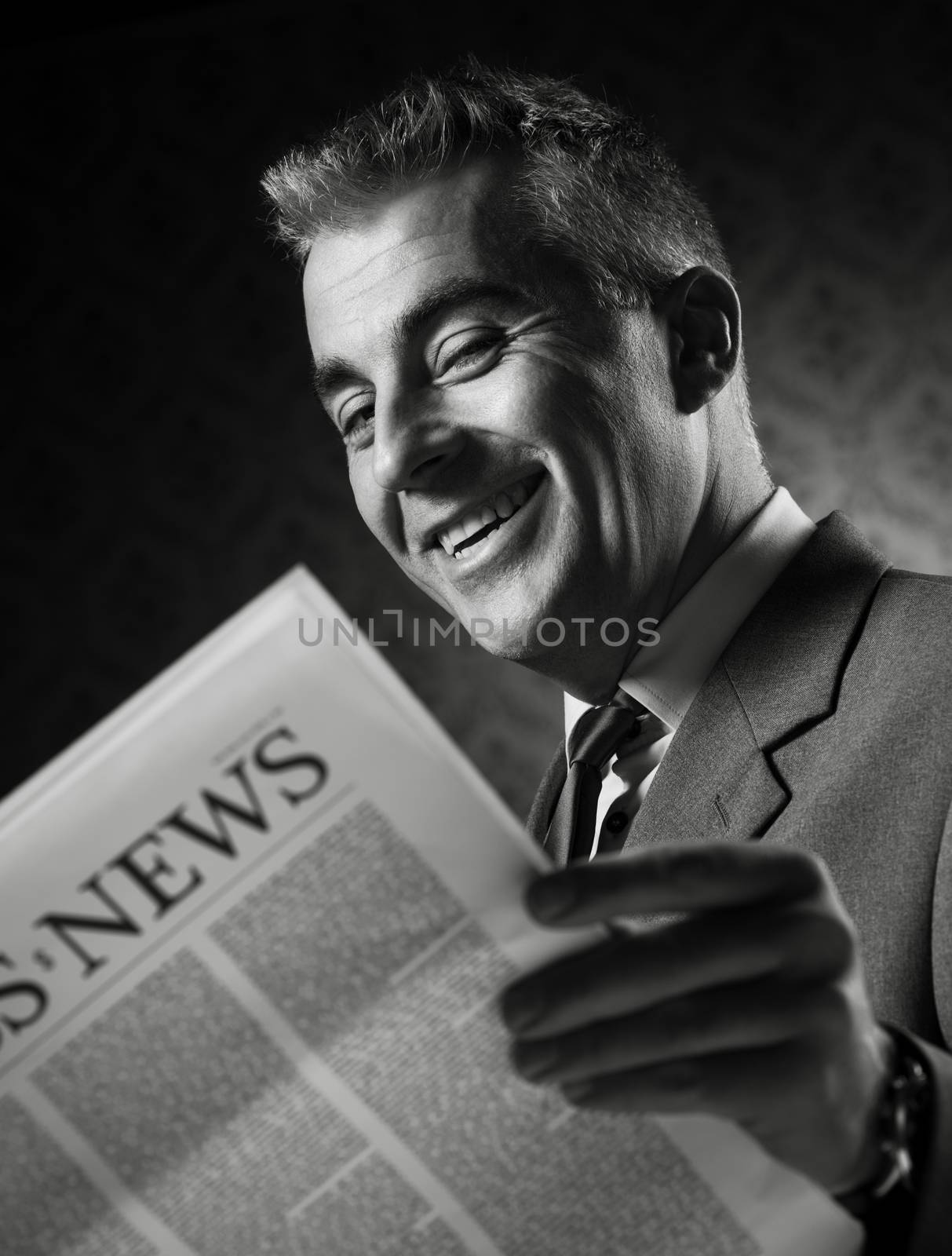 Businessman holding newspaper by stokkete