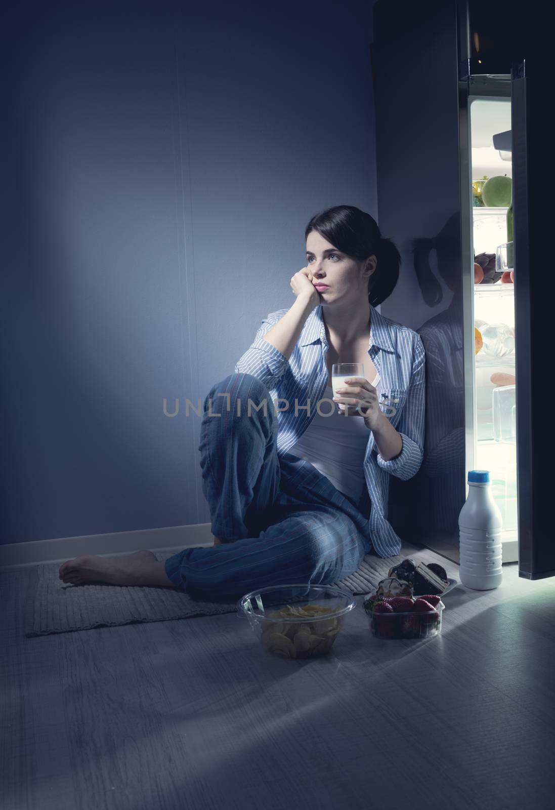 Sleepless woman having a glass of milk by stokkete