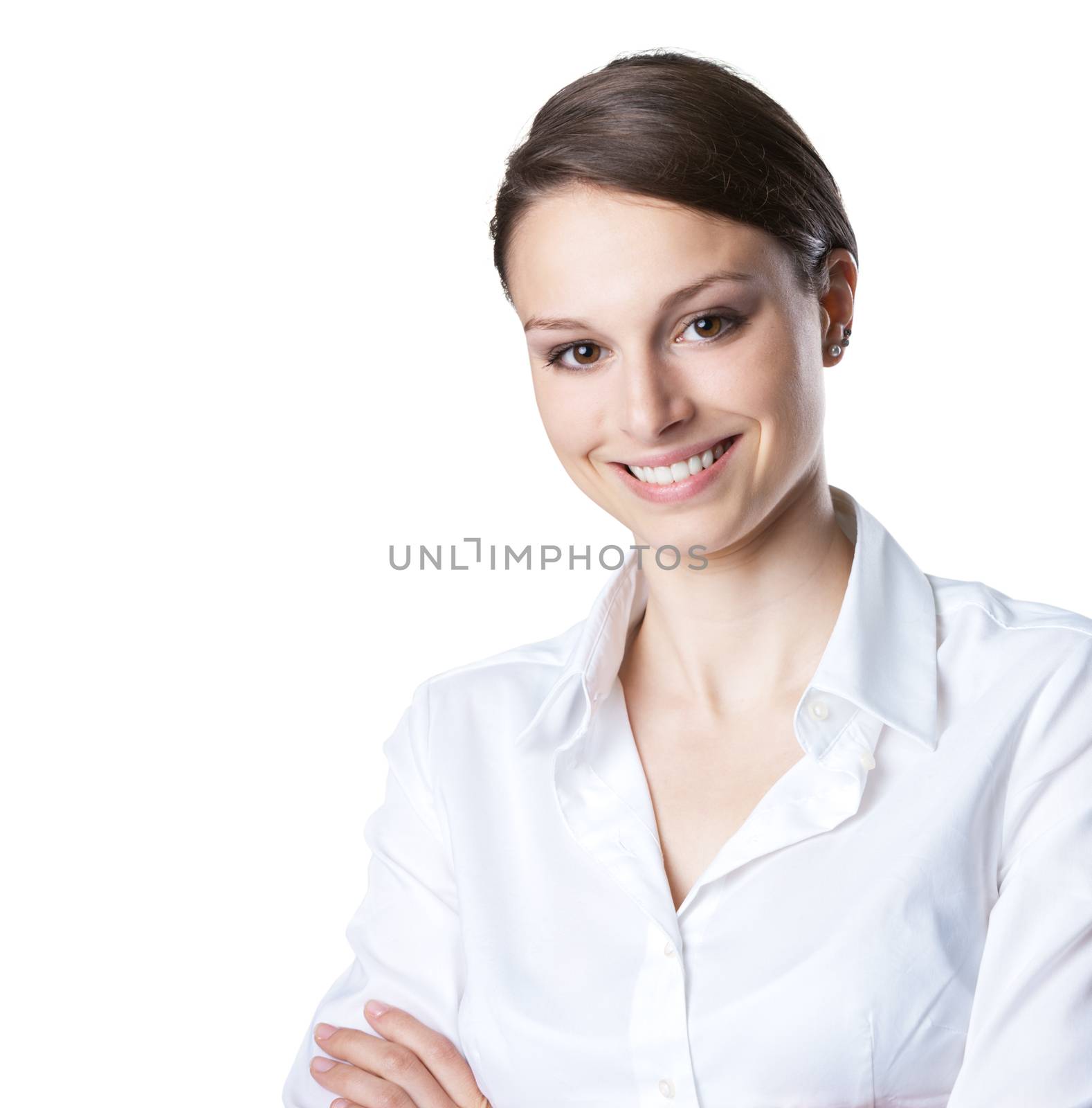 Attractive young woman in white shirt with arms crossed smiling at camera.